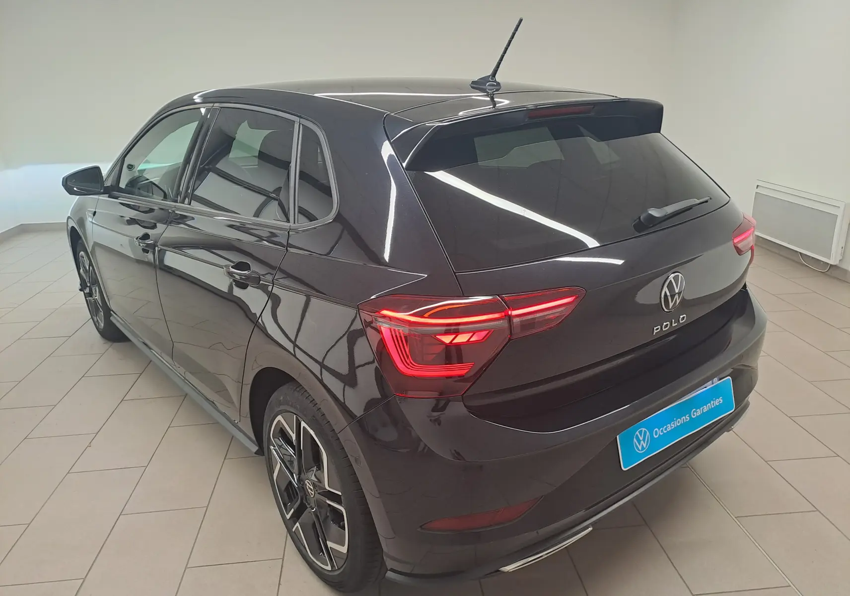 Volkswagen Polo 1.0 TSI R-Line noir intense vue 3/4 arrière droit en intérieur avec jantes alliage distinctives.