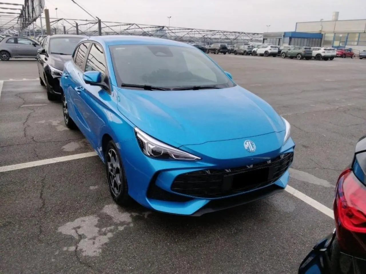Vue 3/4 avant d'une MG3 1.5 Hybrid+ 195 Luxury bleu Como avec calandre noire et phares LED distinctifs.