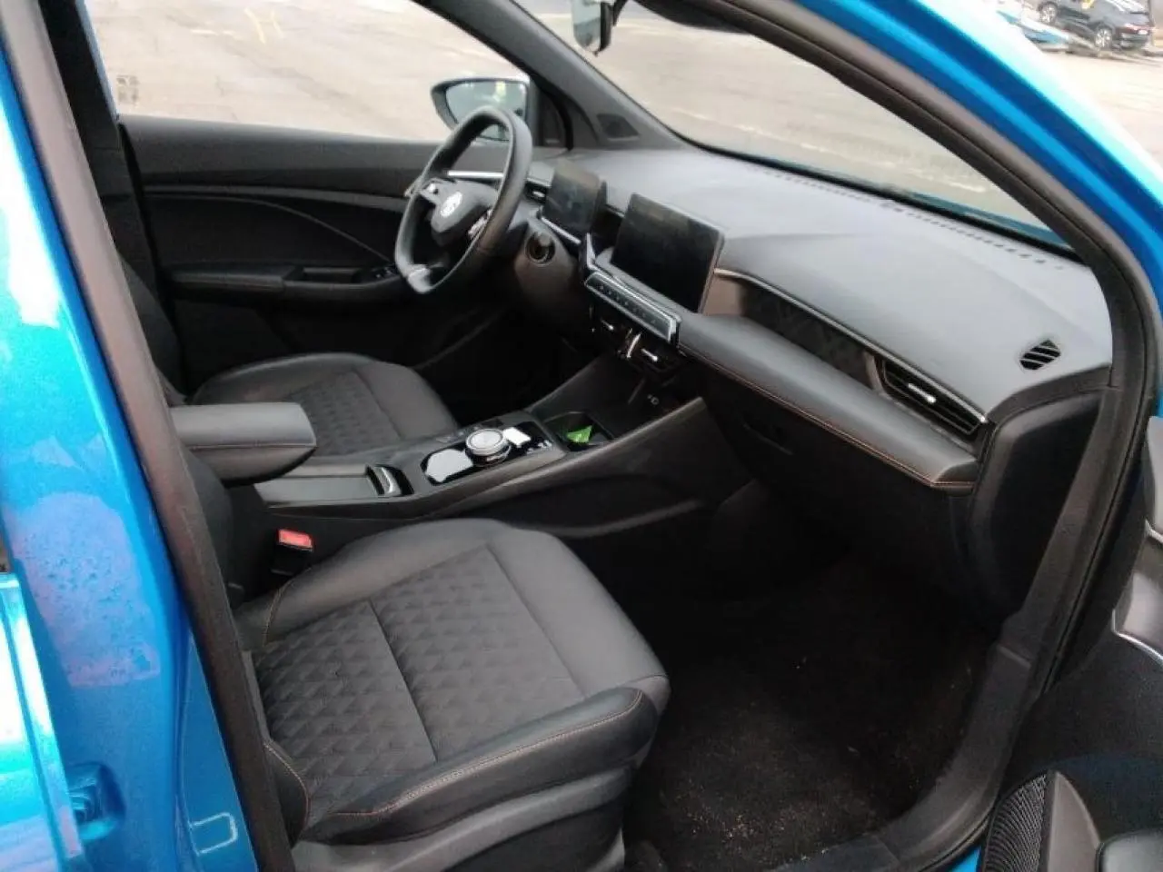 Vue intérieure côté passager avant de la MG3 1.5 Hybrid+ 195 Luxury bleu Como, avec sièges tissu/similicuir noirs et tableau de bord moderne.