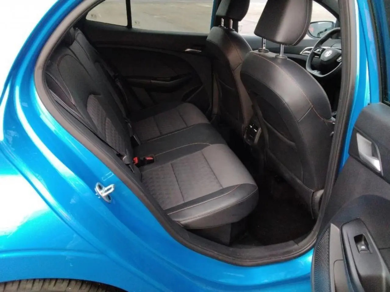 Vue intérieure côté arrière gauche d'une MG3 1.5 Hybrid+ 195 Luxury bleu Como, montrant les sièges arrière en tissu et similicuir noirs.