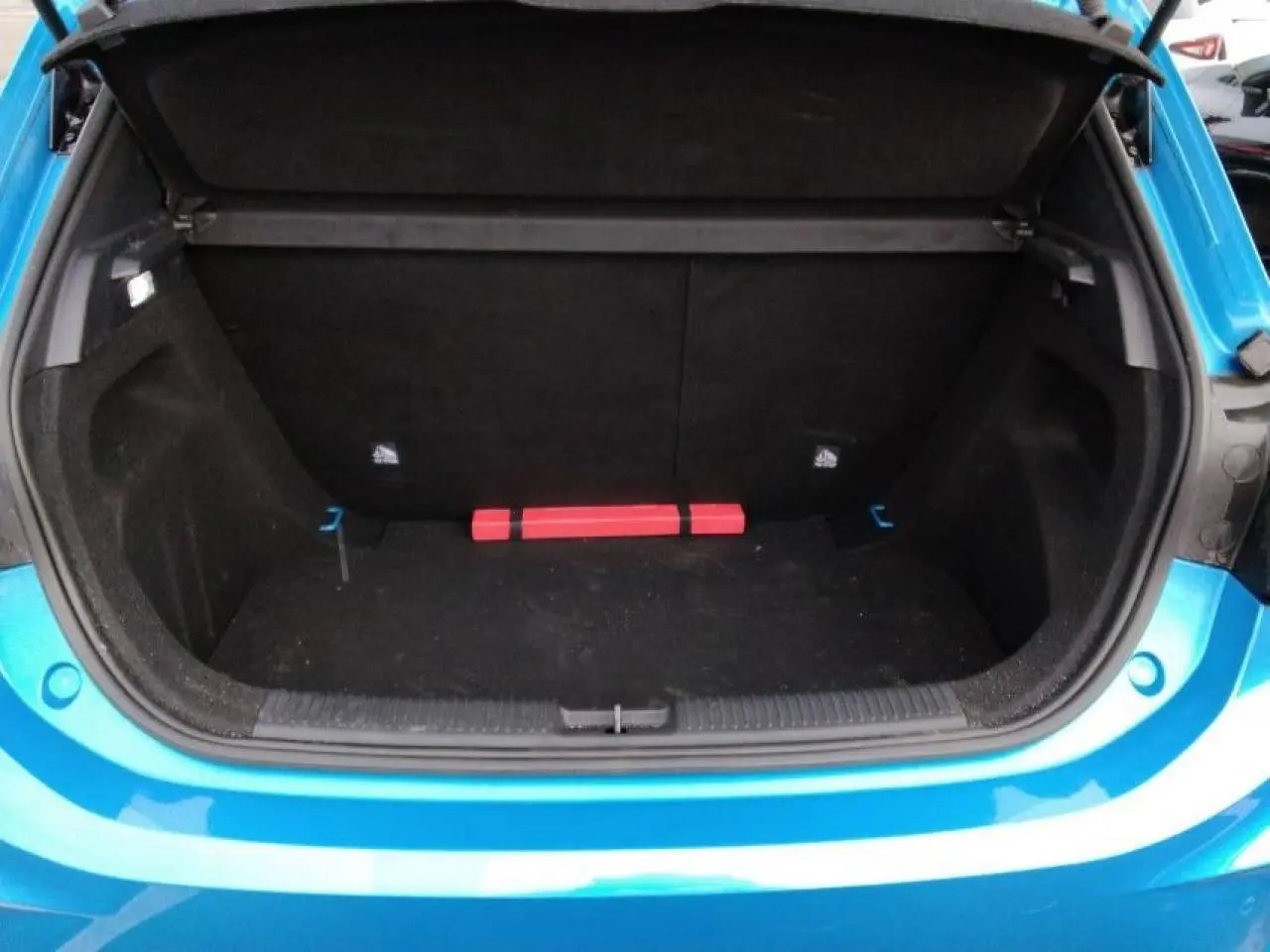 Coffre ouvert vu de l'arrière d'une MG3 1.5 Hybrid+ 195 Luxury bleu Como, avec intérieur noir et triangle de sécurité.