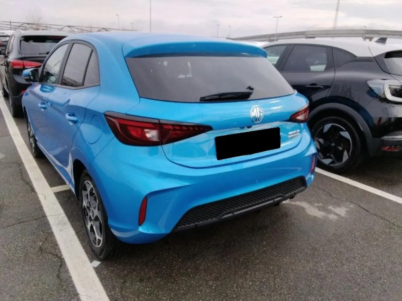 Vue 3/4 arrière droite d'une MG3 1.5 Hybrid+ 195 Luxury bleu Como avec vitres arrière surteintées.