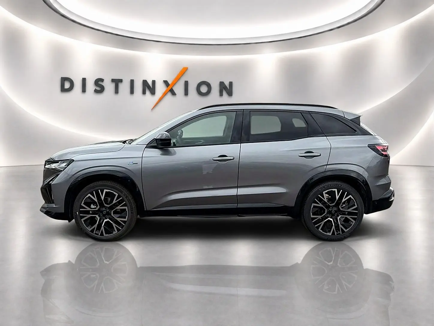 Profil droit du Renault Austral gris schiste 2026 avec jantes alu noires et toit noir dans un showroom lumineux.
