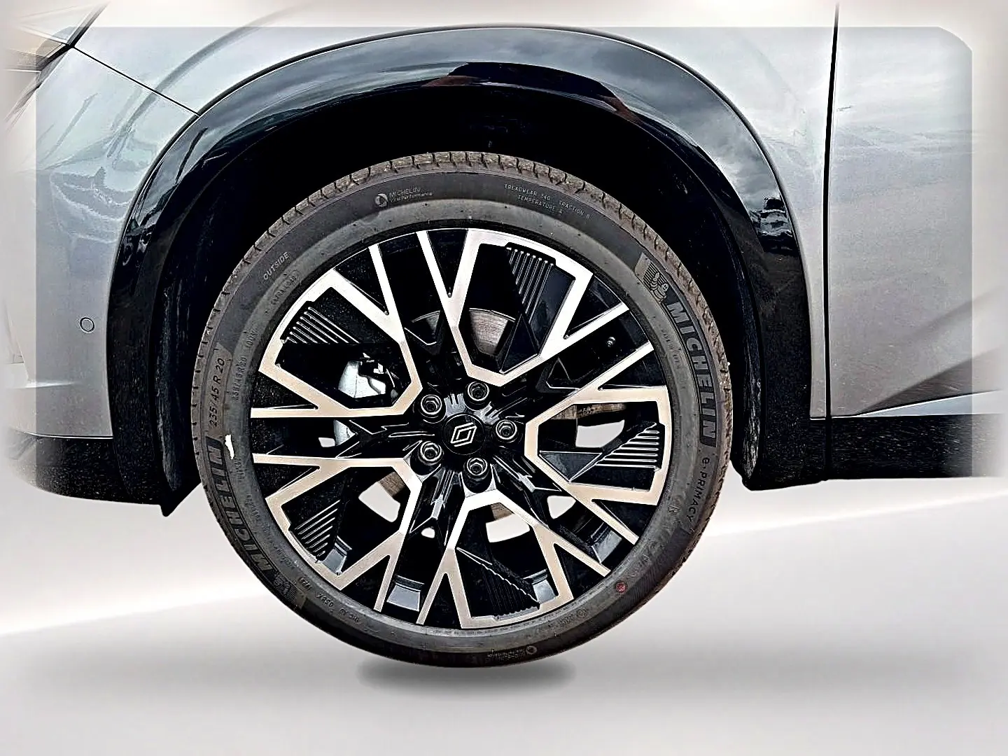 Gros plan sur la roue avant droite du Renault Austral gris schiste avec jante alliage noire et argentée design moderne.
