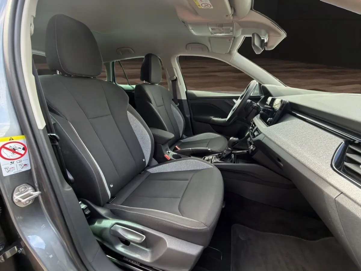 Intérieur de la Skoda Scala gris foncé vu côté conducteur, montrant sièges avant et tableau de bord moderne.
