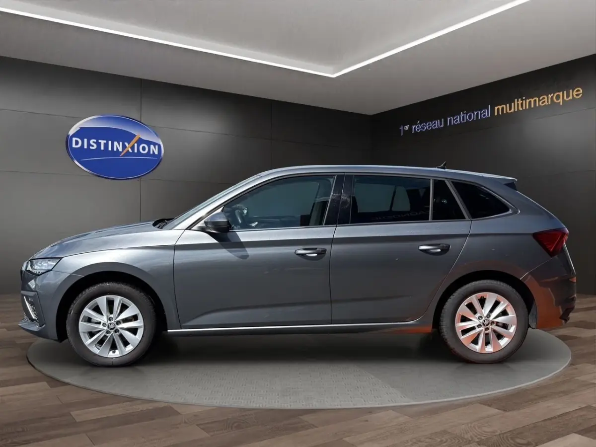 Vue latérale droite d'une Skoda Scala gris foncé en showroom avec jantes alliage et vitres teintées.