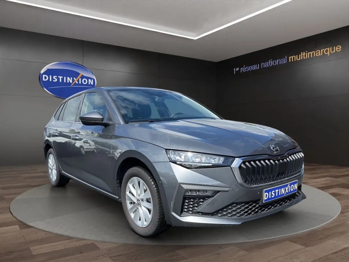 Vue 3/4 avant droite d'une Skoda Scala gris foncé avec calandre noire et jantes argentées en showroom.