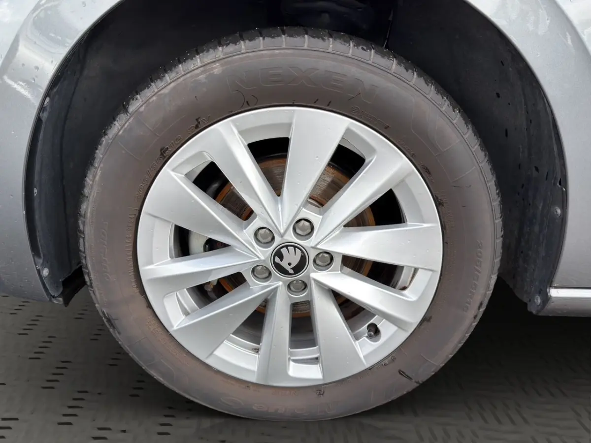 Gros plan sur la roue avant droite grise d'une Skoda Scala 2025 avec jante alliage et logo au centre.