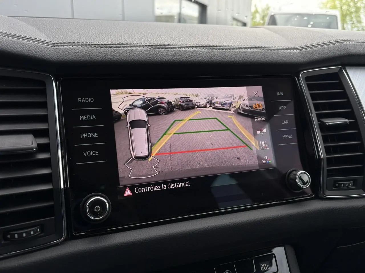 Écran central du Skoda Kodiaq 2024 affichant la caméra de recul avec vue aérienne et lignes de guidage.