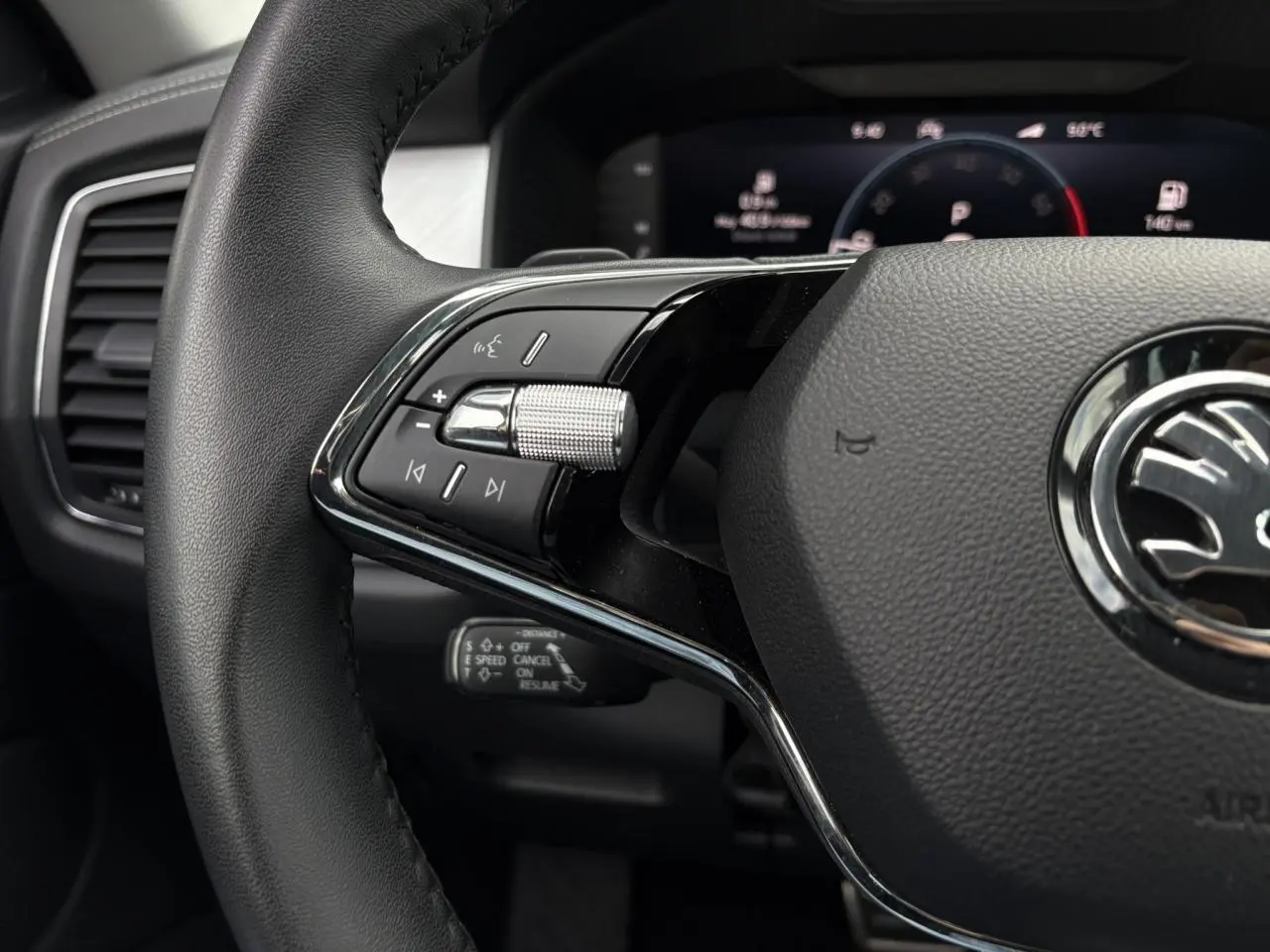 Gros plan sur le volant noir du Skoda Kodiaq 2024 avec commandes intégrées et tableau de bord digital en arrière-plan.