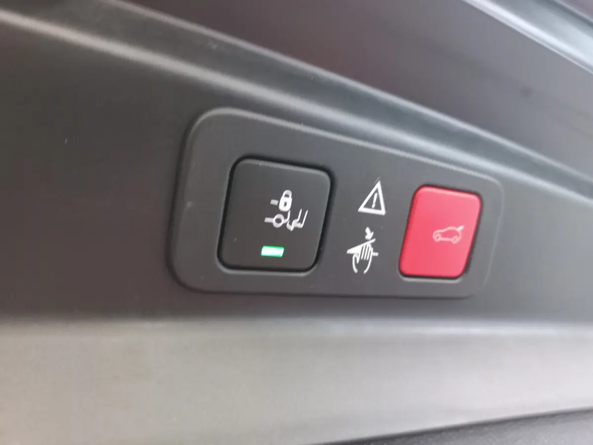 Gros plan sur les boutons de commande de la fermeture et alarme du coffre du Peugeot 5008 gris foncé.