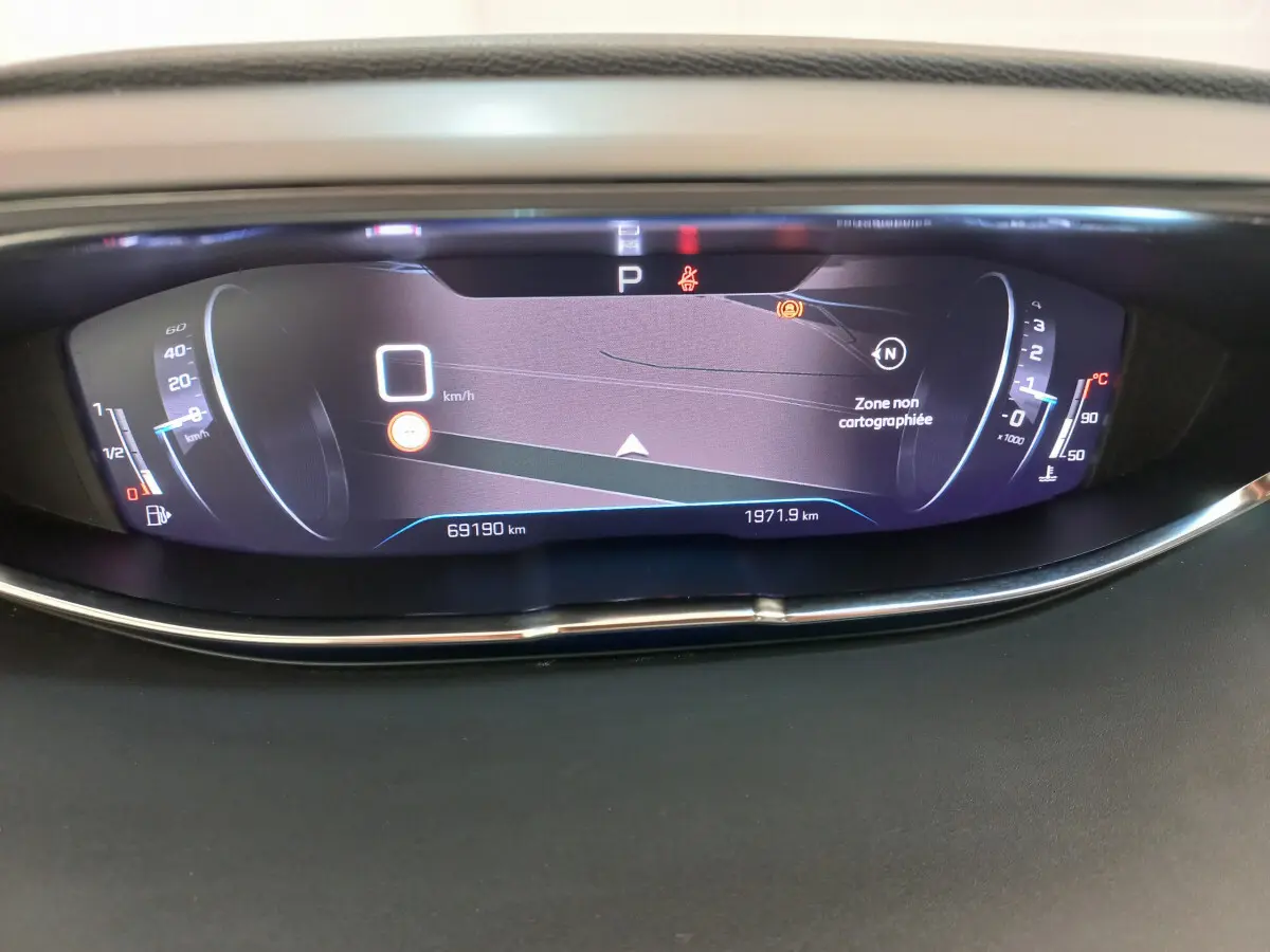 Affichage numérique du tableau de bord du Peugeot 5008 gris foncé, indiquant vitesse et informations de navigation.