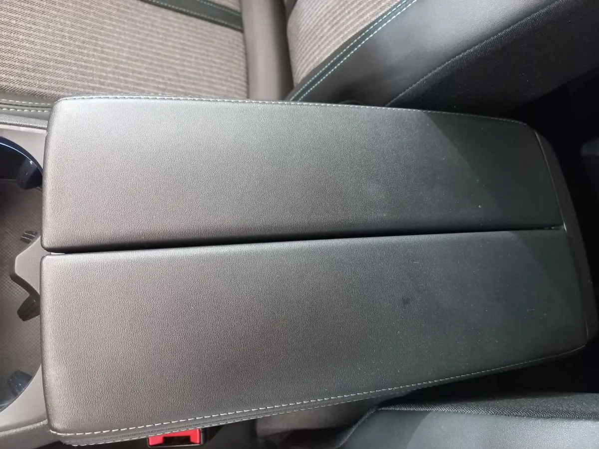 Accoudoir central noir en cuir avec surpiqûres blanches dans l'habitacle du Peugeot 5008 gris foncé, version 2021.