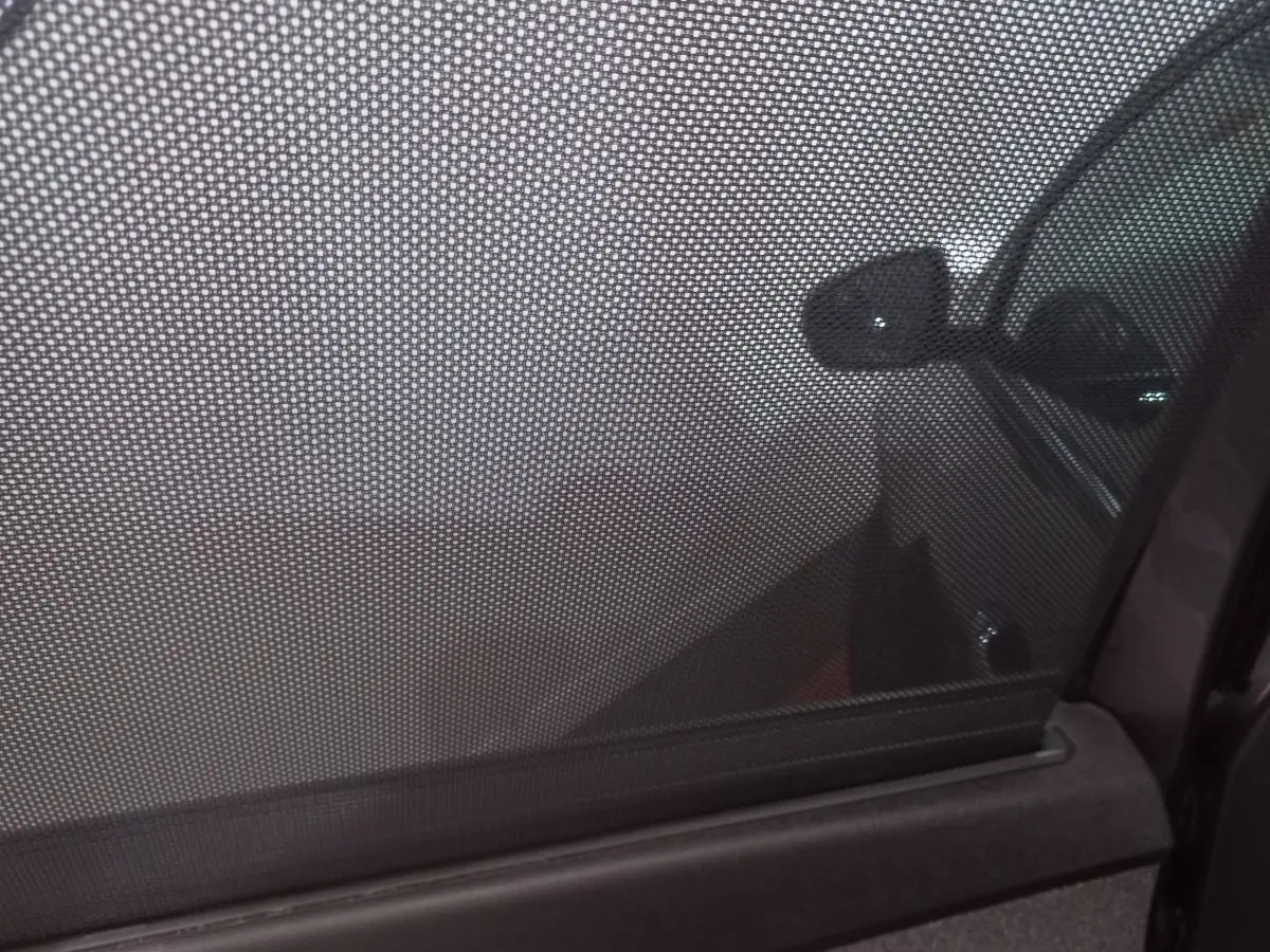Vue intérieure côté droit du PEUGEOT 5008 gris foncé avec store pare-soleil sur la vitre arrière.
