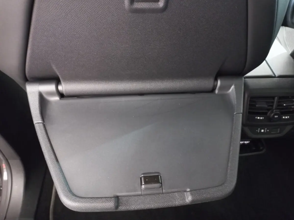 Détail de la tablette rabattable noire au dos du siège avant dans l'habitacle du Peugeot 5008 gris foncé