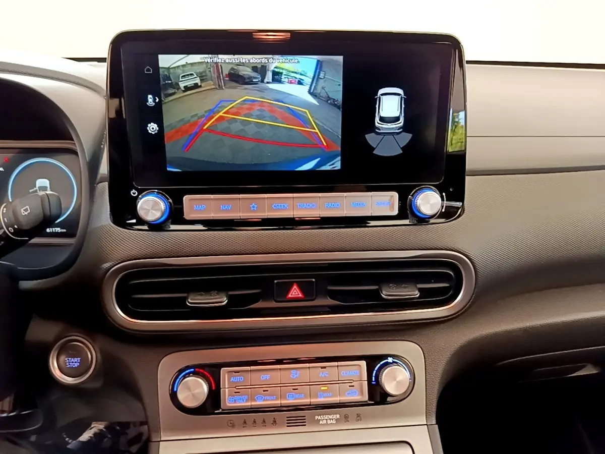 Vue intérieure du tableau de bord de la Hyundai Kona électrique 2023 avec écran tactile affichant la caméra de recul.