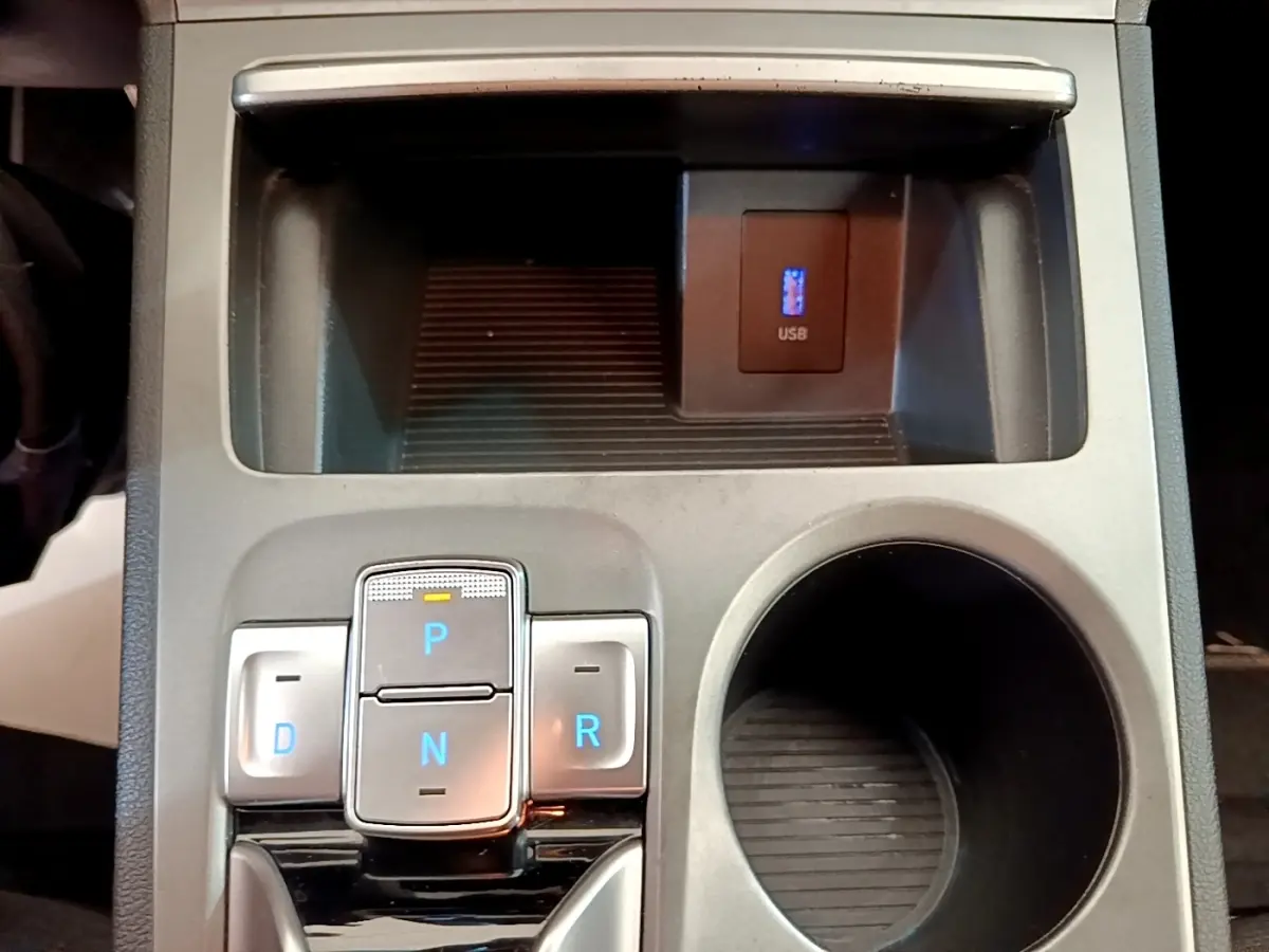 Vue rapprochée de la console centrale du Hyundai Kona électrique 2023, avec boutons de boîte auto et prise USB.