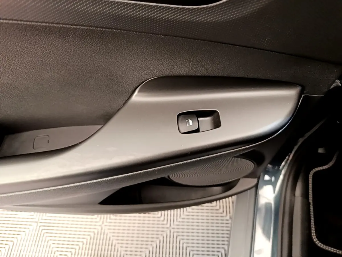 Détail de la commande de verrouillage sur la porte avant droite du Hyundai Kona électrique bleu 2023.