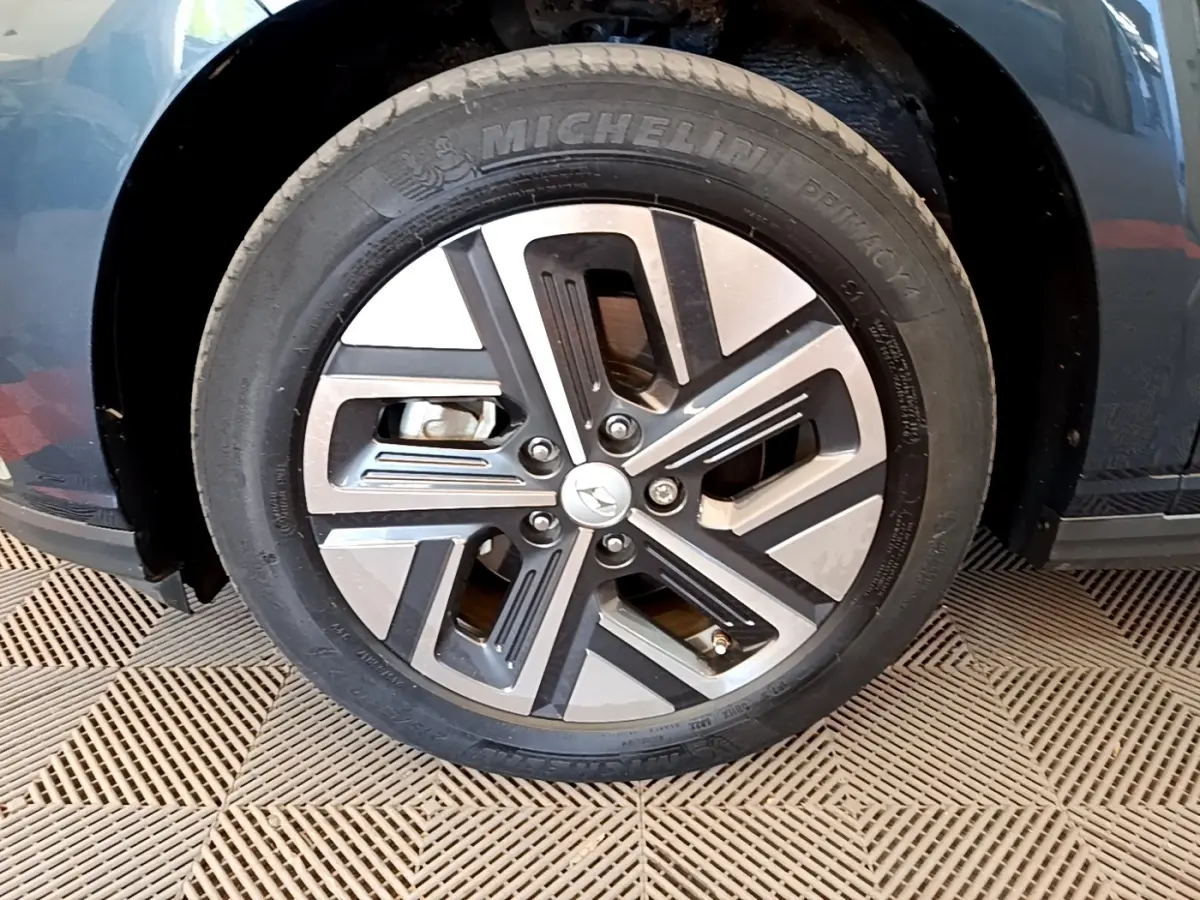 Gros plan sur la roue avant gauche du Hyundai Kona électrique bleu, avec jante alliage et pneu Michelin.