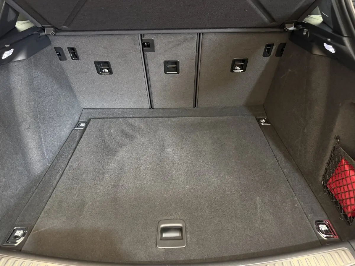 Vue intérieure du coffre gris foncé du Porsche Macan 3.0 S 2019, montrant un espace propre et bien organisé avec filet latéral.