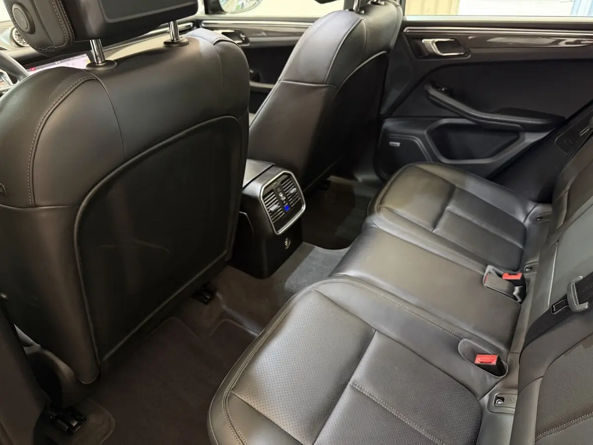 Vue intérieure arrière du Porsche Macan 3.0 S 2019, sièges en cuir noir et console centrale avec ventilation.