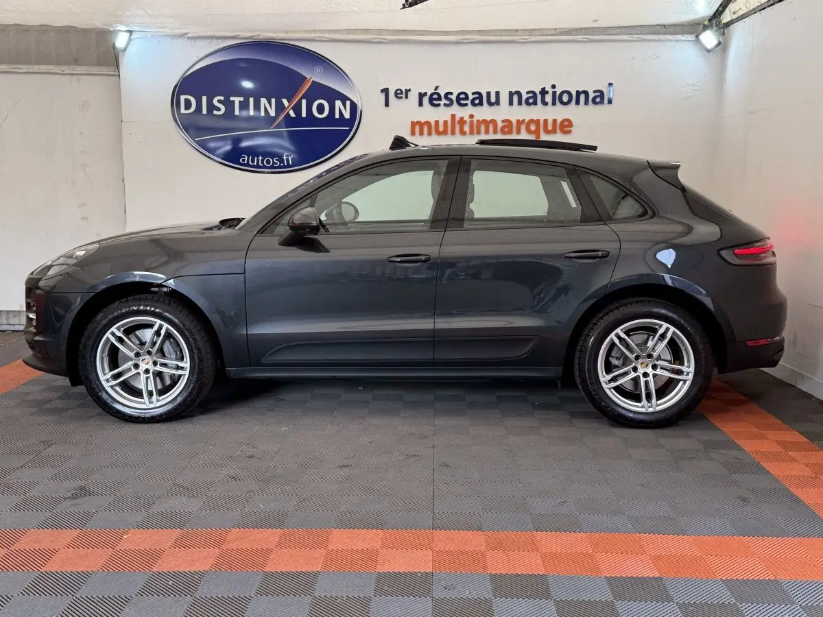 Vue latérale droite d'un Porsche Macan 3.0 S gris foncé avec jantes alliage cinq branches en intérieur showroom.