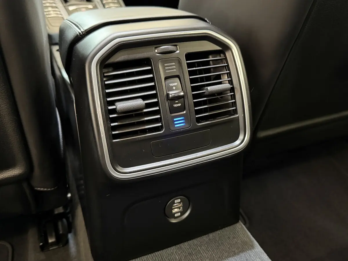 Détail des aérateurs arrière avec commande de température et prises USB dans un Porsche Macan 3.0 S gris foncé.