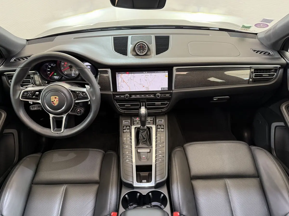 Vue intérieure frontale du tableau de bord et volant cuir alu du Porsche Macan 3.0 S gris foncé de 2019.
