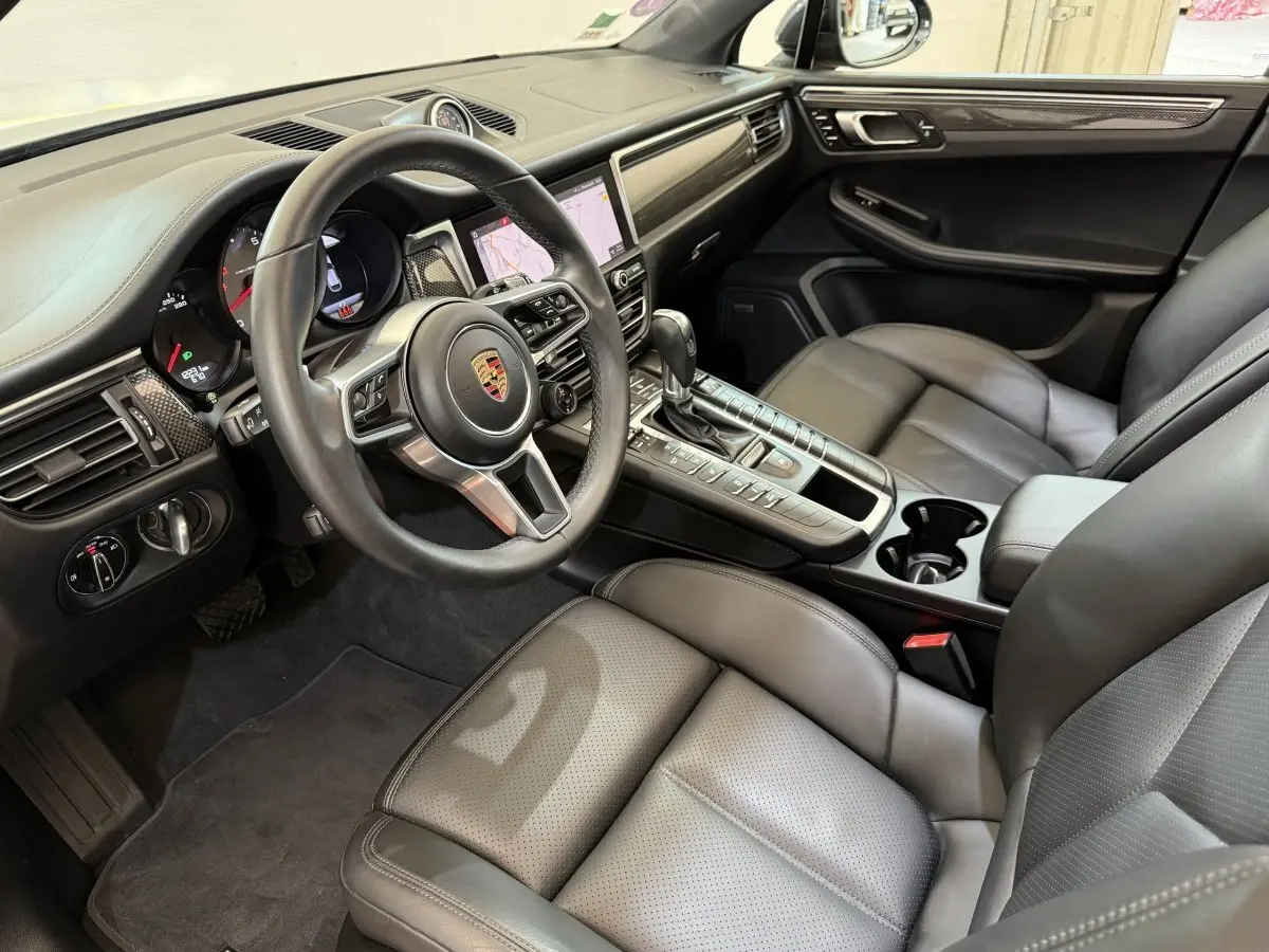Vue intérieure côté conducteur du Porsche Macan 3.0 S 2019, montrant volant cuir alu, tableau de bord et sièges gris foncé.