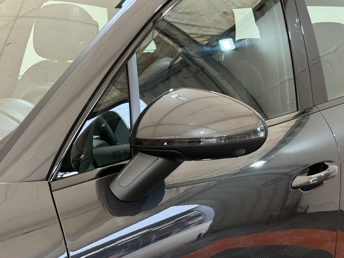 Gros plan sur le rétroviseur côté gauche d’un Porsche Macan 3.0 S gris foncé avec poignée de porte visible.