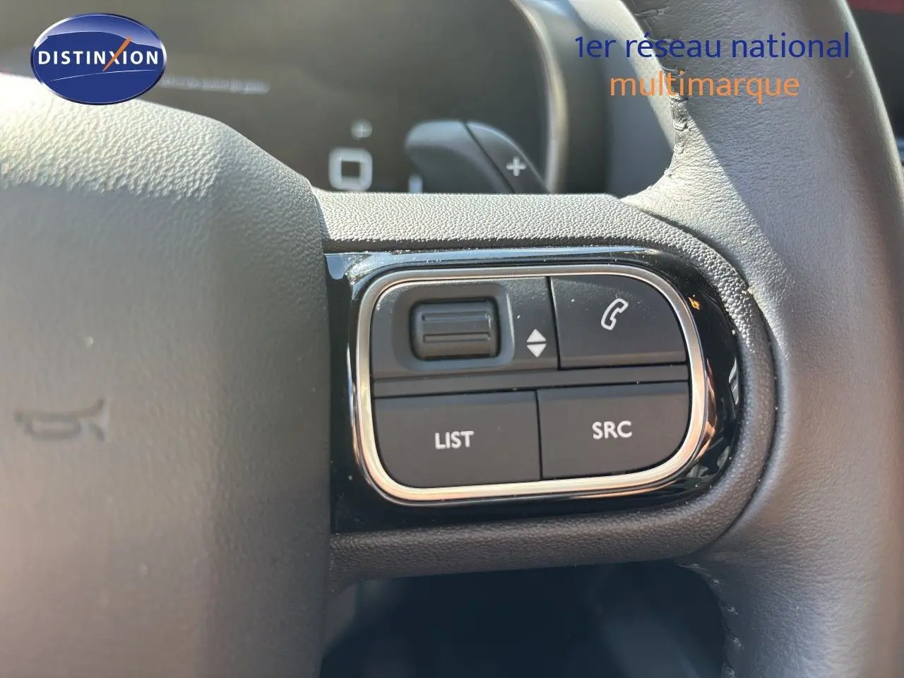 Gros plan sur les commandes au volant du Citroën C5 Aircross 2025, finition noire avec boutons multifonctions.
