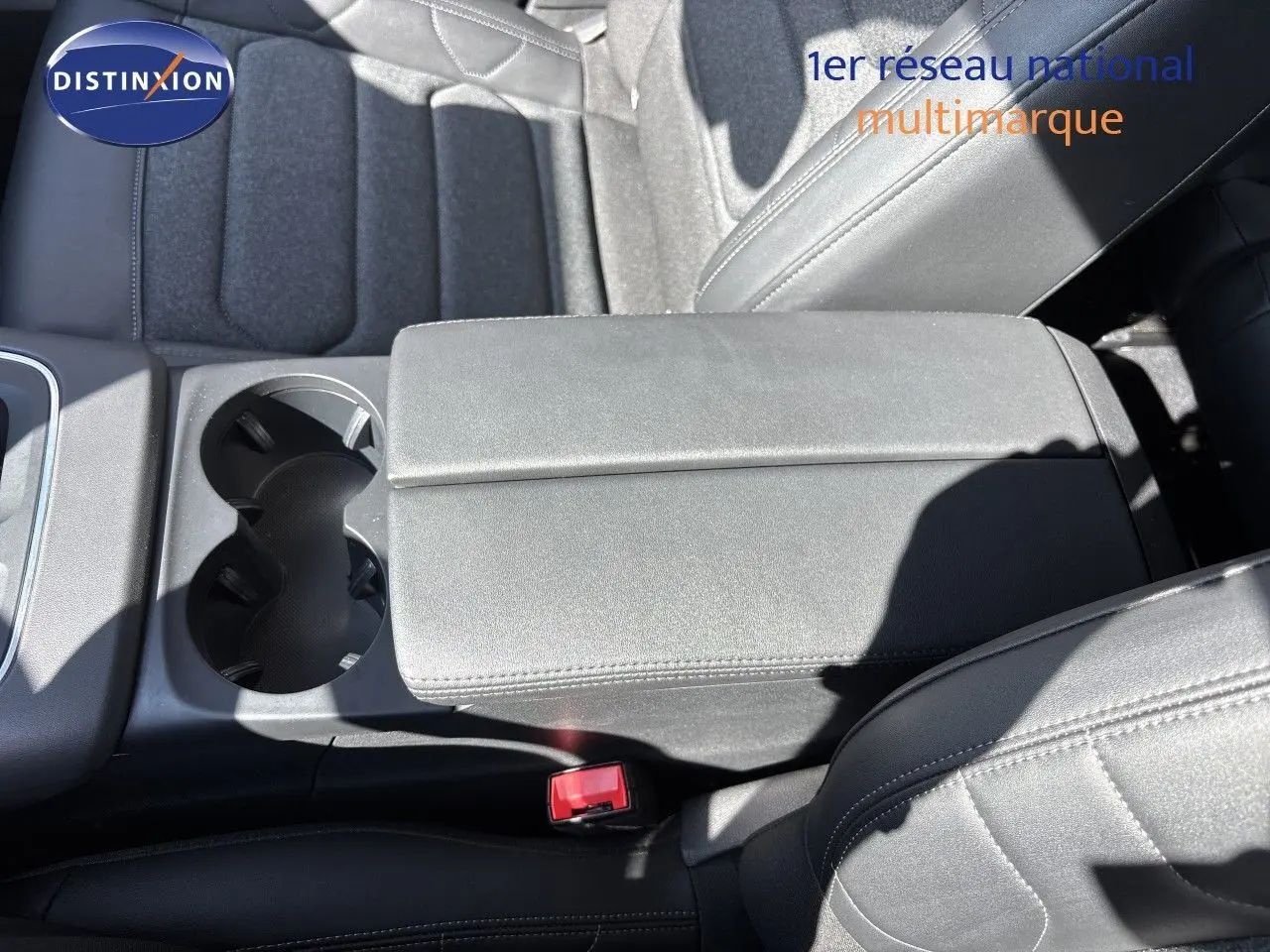 Vue rapprochée de l'accoudoir central et des sièges noirs en tissu et cuir du Citroën C5 Aircross 2025.