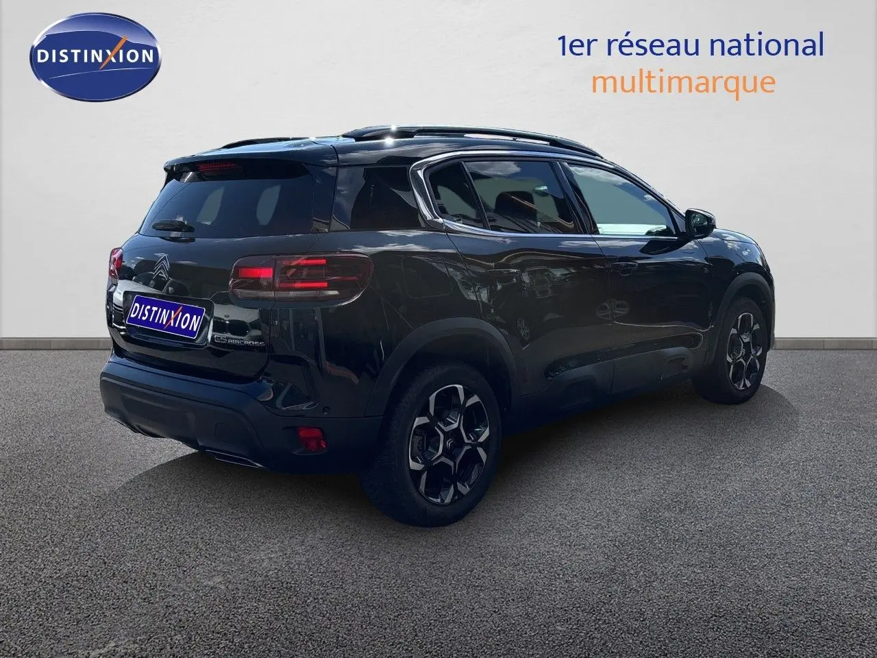 Vue 3/4 arrière droite d'un Citroën C5 Aircross noir Perla Nera métallisé avec jantes noires et toit panoramique.