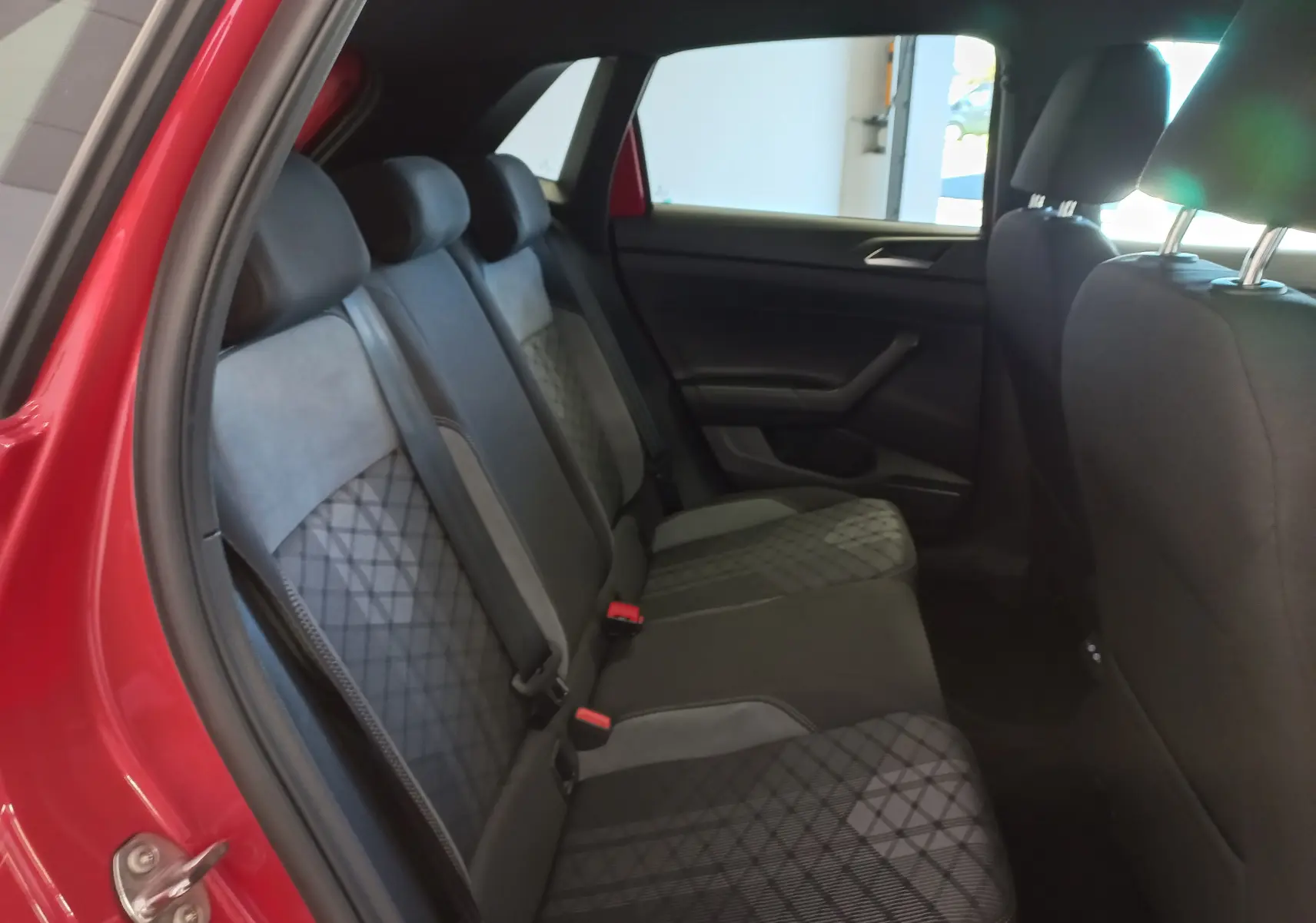 Vue intérieure côté gauche des sièges arrière de la Volkswagen Polo Rouge Roi 2025 avec sellerie tissu et alcantara à motifs géométriques.