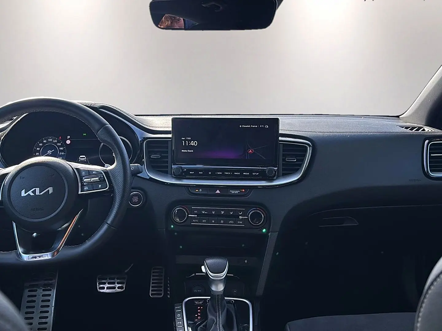 Vue intérieure frontale du tableau de bord noir du KIA Xceed 2024 avec écran tactile et volant multifonction.
