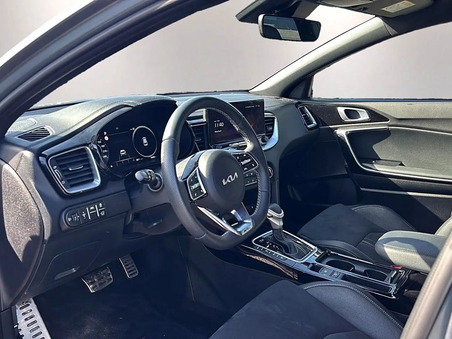 Intérieur avant du Kia Xceed gris 2024, vue côté conducteur, volant cuir multifonction et console centrale avec boîte auto.