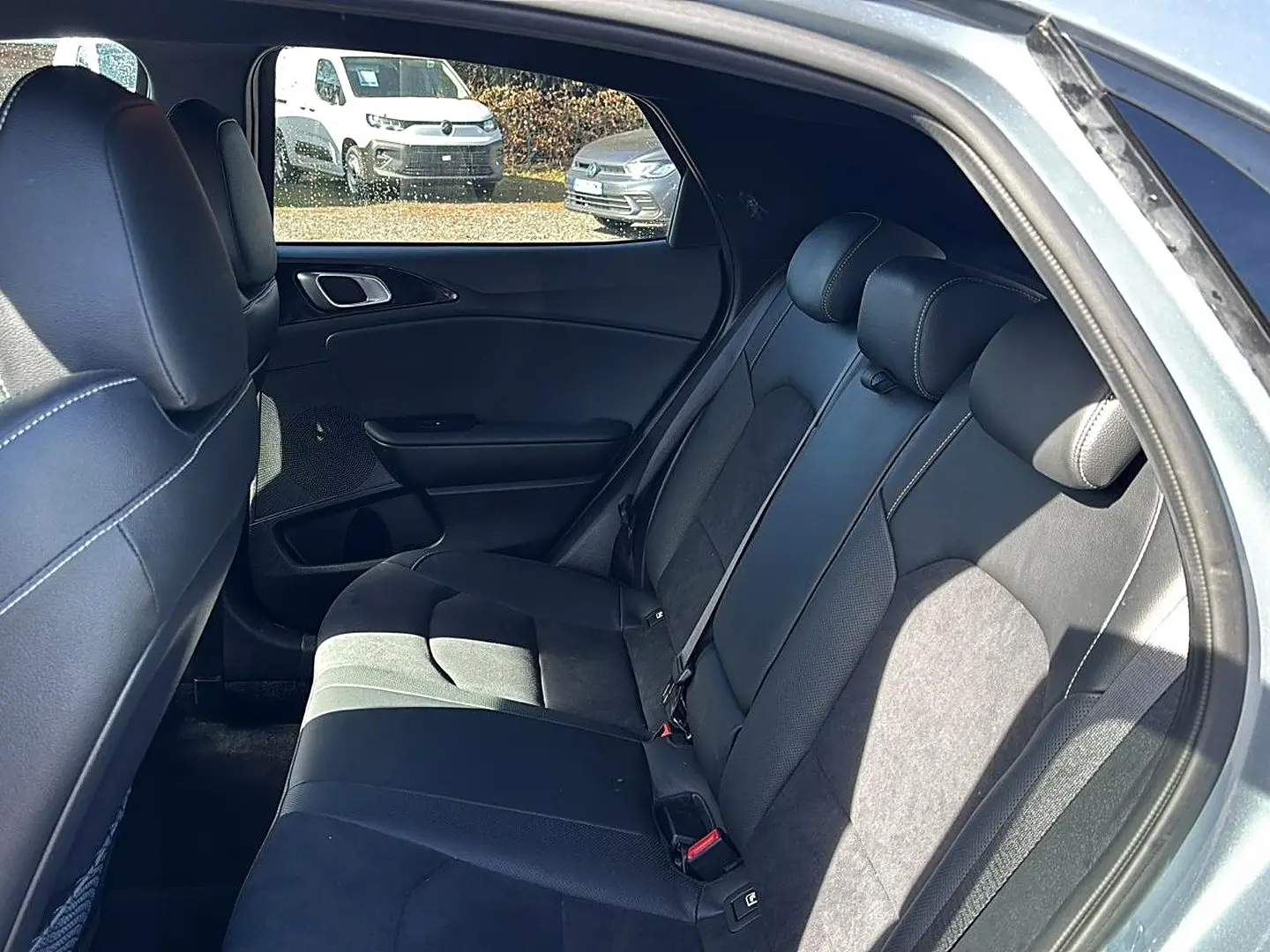 Vue intérieure côté droit sur la banquette arrière en cuir noir du KIA Xceed gris 2024, avec appuie-têtes et ceinture visible.