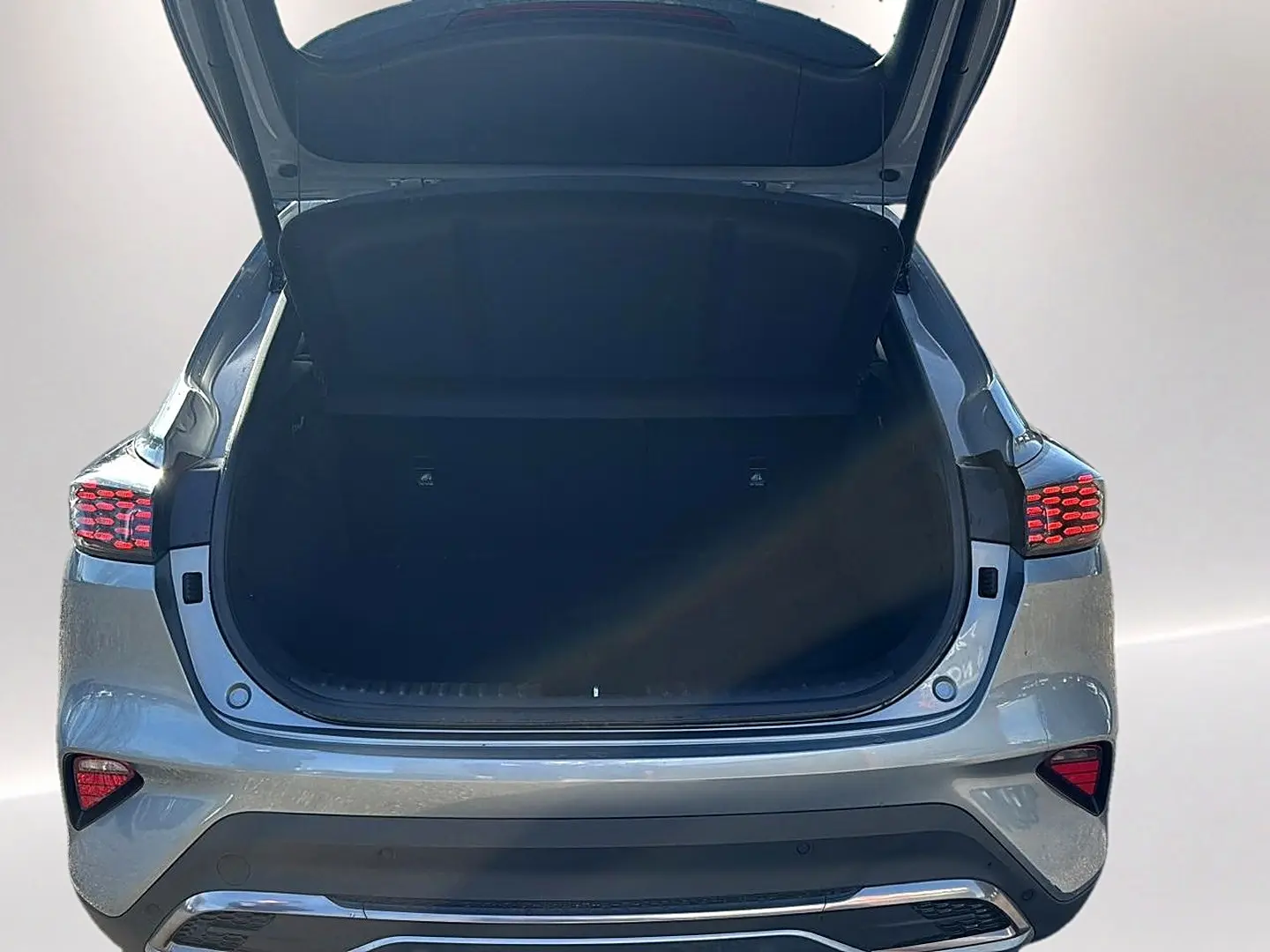 Vue arrière du Kia Xceed gris 2024 avec coffre ouvert et feux arrière LED allumés.