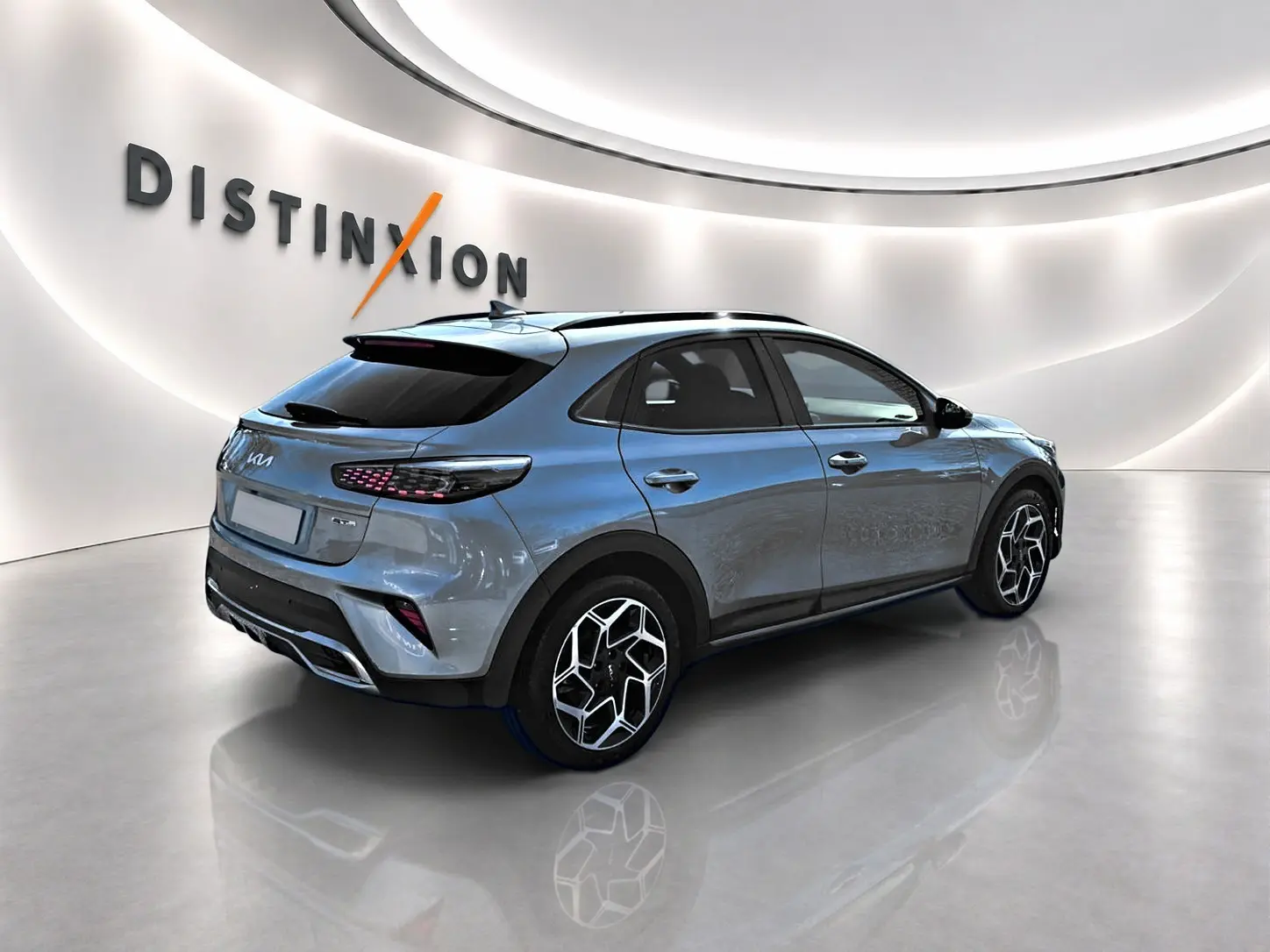 KIA Xceed gris 3/4 arrière droit en showroom avec jantes alu et vitres surteintées.