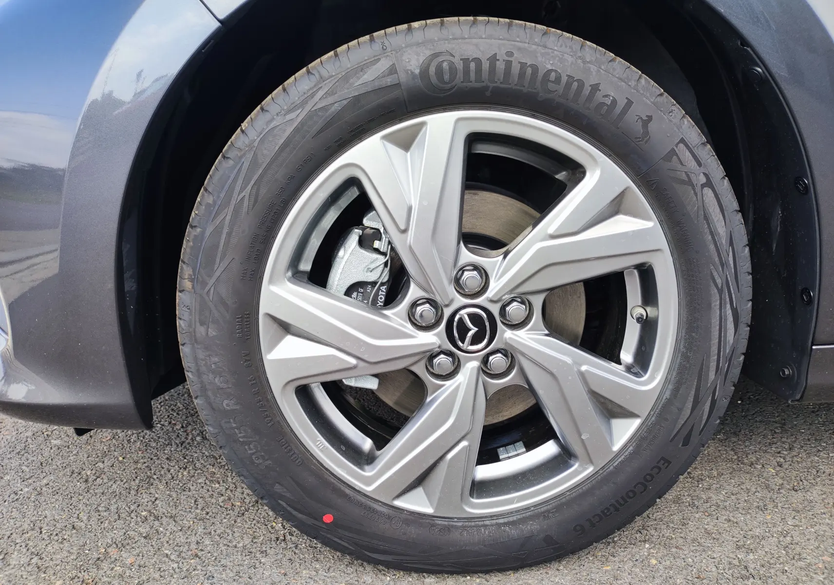 Gros plan sur la roue avant droite gris foncé d'une Mazda2 1.5 Hybrid Exclusive Line 2024 avec jante alliage et pneu Continental.