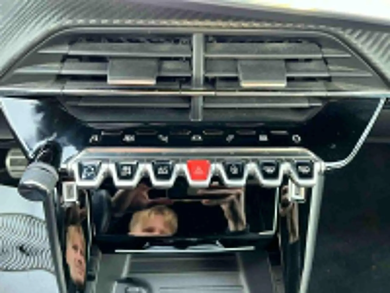 Vue rapprochée de la console centrale du Peugeot 2008 II avec ses commandes piano et aérateurs noirs brillants.