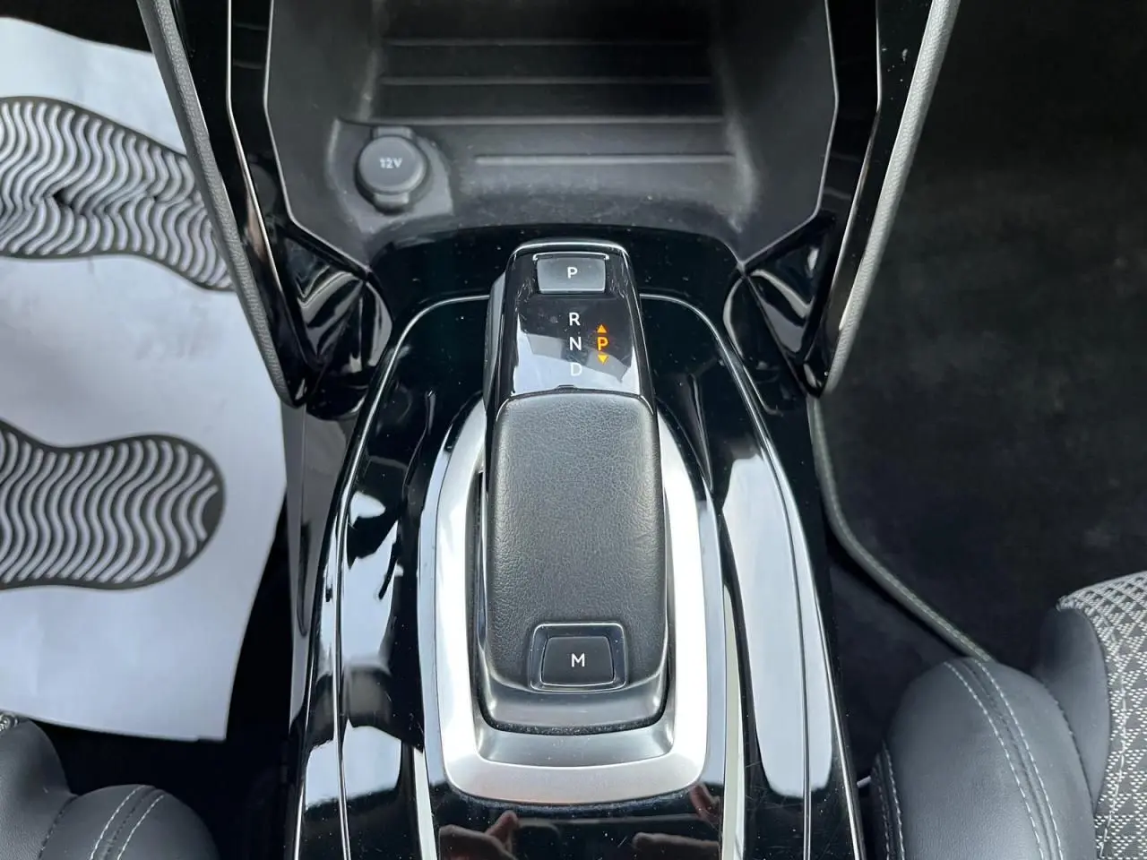 Le levier de vitesses automatique noir brillant de la Peugeot 2008 II vue en gros plan intérieur.