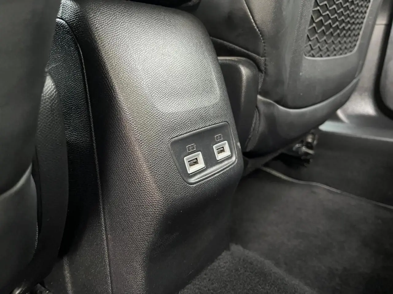 Prise USB double vue rapprochée à l'arrière des sièges noirs dans le Peugeot 2008 gris Artense toit noir.