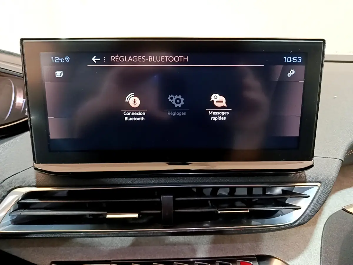Écran tactile central du tableau de bord du Peugeot 5008 bleu, affichant les réglages Bluetooth.