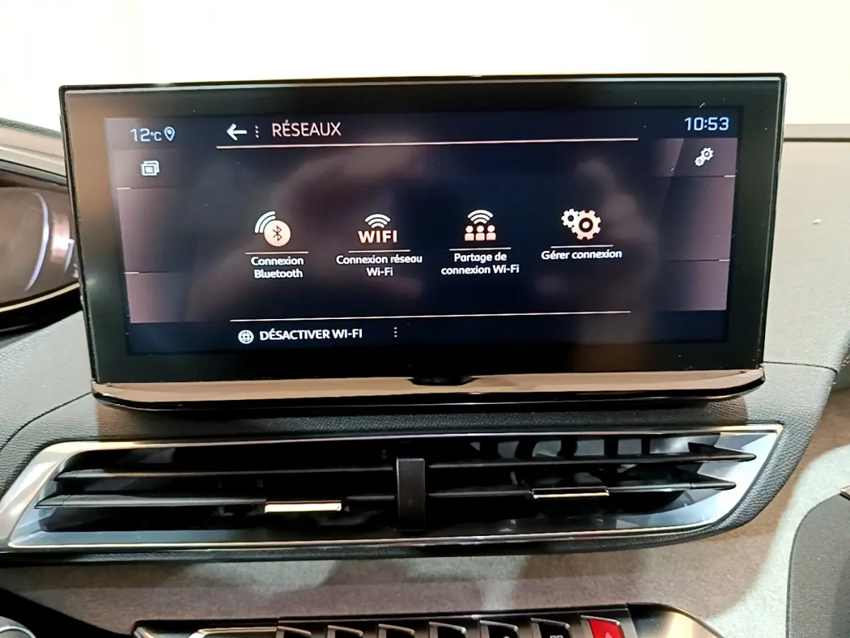 Écran tactile central affichant les options Wi-Fi et Bluetooth sur le tableau de bord du Peugeot 5008 GT bleu 2021