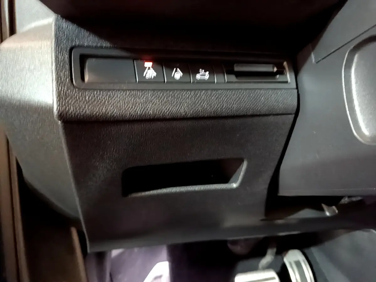 Gros plan sur les commandes sous le tableau de bord côté conducteur du Peugeot 5008 GT bleu 2021.