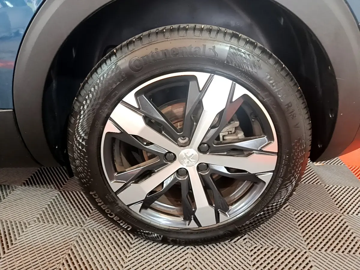 Gros plan sur la roue avant droite du Peugeot 5008 bleu, mettant en valeur la jante alliage et le pneu Continental.