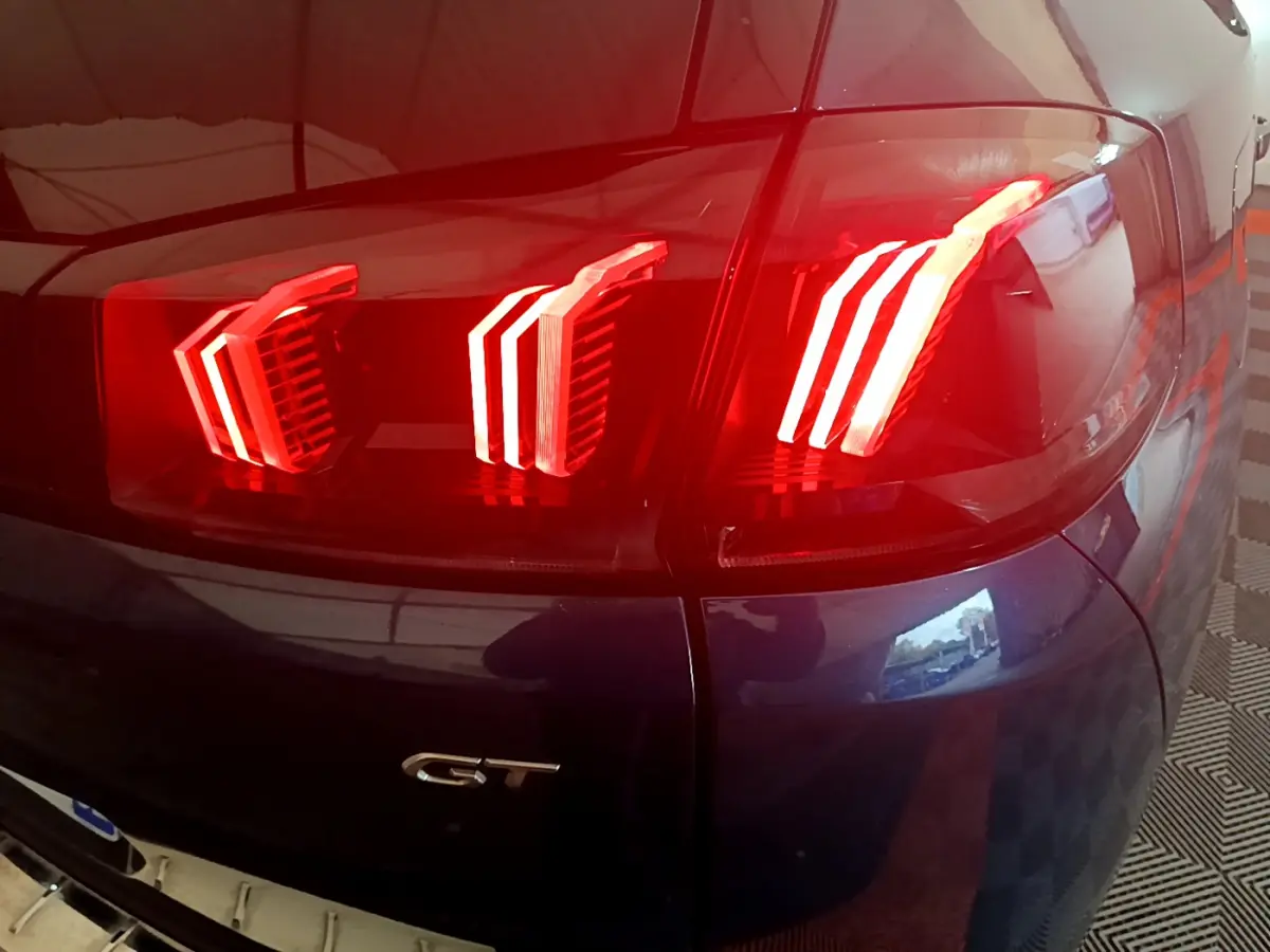 Gros plan sur le feu arrière droit rouge et badge GT du Peugeot 5008 bleu, version PureTech 130 S&S EAT8 GT.