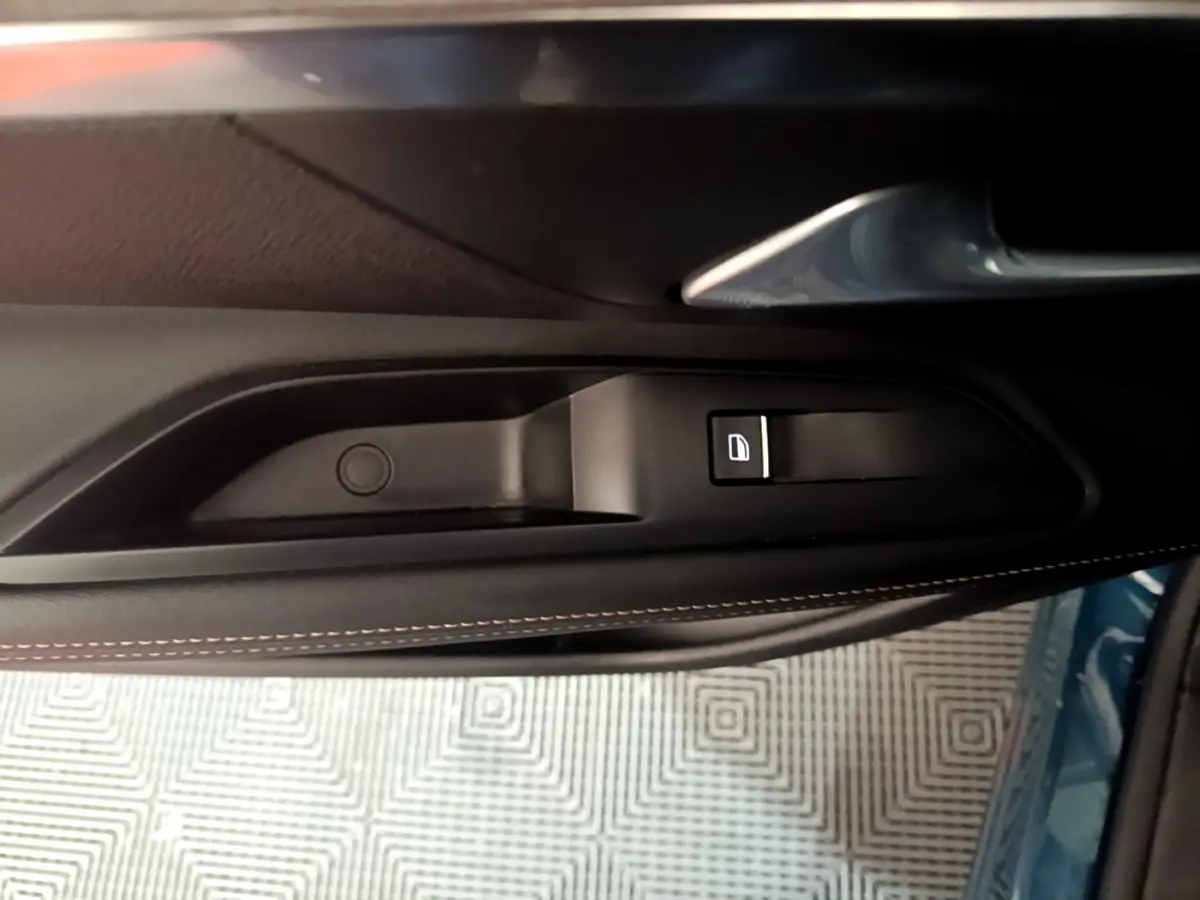 Bouton de verrouillage des portes sur la portière côté conducteur du Peugeot 5008 GT bleu, intérieur noir avec surpiqûres.
