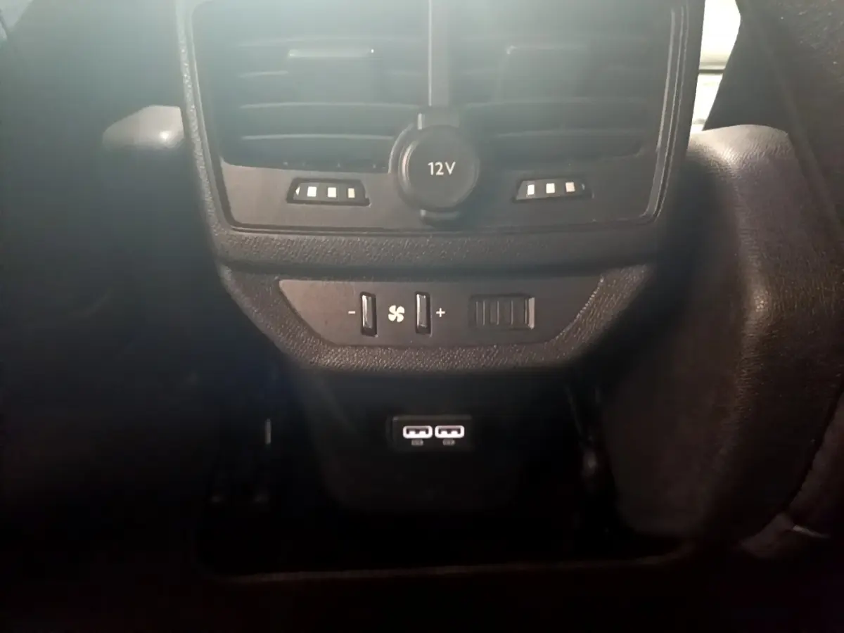 Vue rapprochée de la console arrière du Peugeot 5008 bleu 2021, avec prises USB, prise 12V et commandes de ventilation.